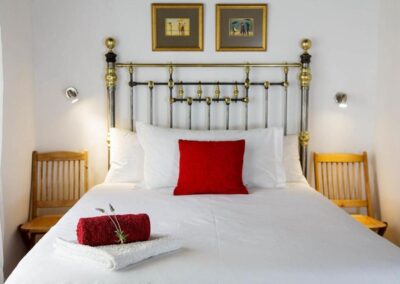 Bed with whiite linen and red pillow